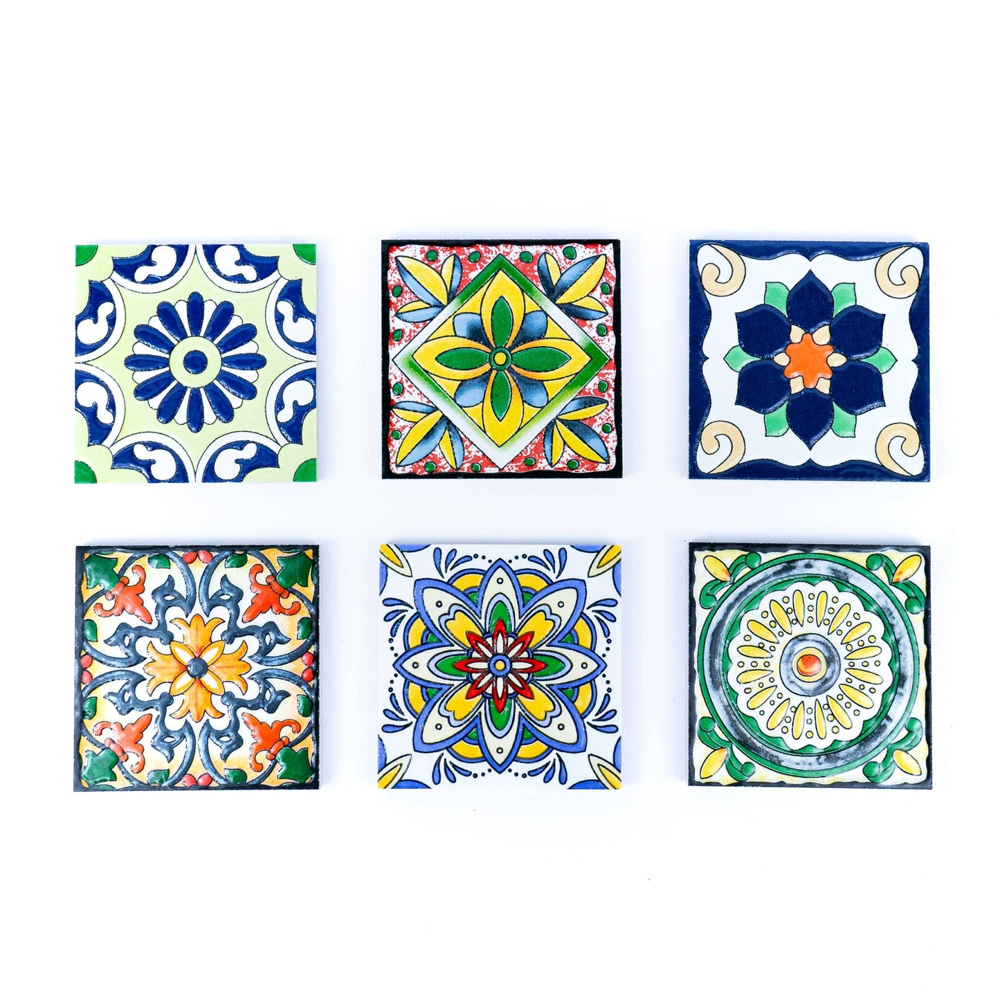 The Meninas Bonitas Cork Tile-Inspired Ceramic & Cork Coasters (Set of 6) feature colorful geometric and floral designs, capturing the charm of traditional Portuguese tiles. Arranged neatly, each piece adds a vibrant touch to your table.