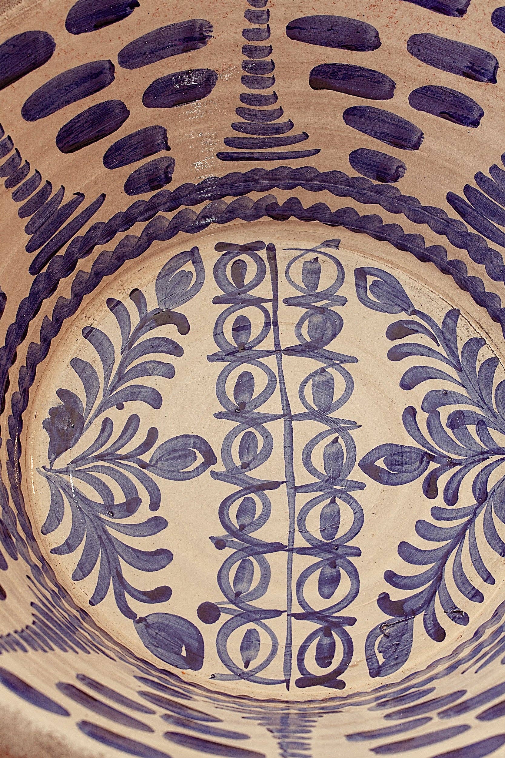 A close-up of the Blue Lebrillos Granaínos Bowl by Eturel Madrid, showcasing hand-painted blue floral and geometric patterns on a beige ceramic base, inspired by traditional Andalusian pottery.