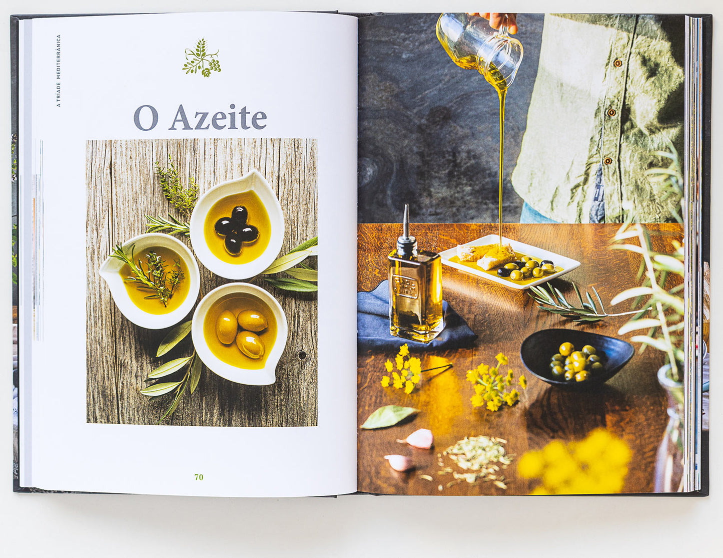 A cookbook spread showcases ObjectoAnonimos Bread, Olive Oil & Wine: bowls of olives, fresh herbs, and olive oil beside a scene of pouring oil onto bread—a vibrant tribute to the Mediterranean diet.