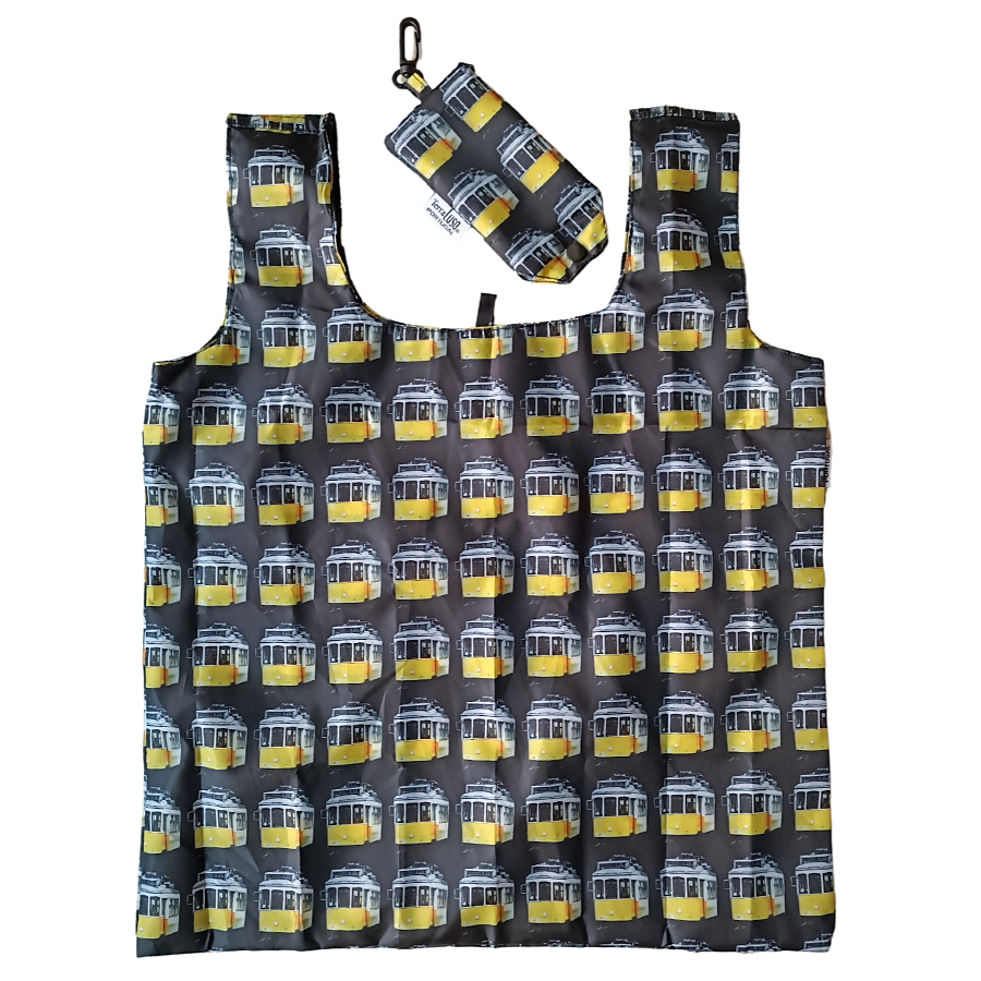 The Terra Lusa "Tram" Eco Shopper is a reusable, eco-friendly bag with matching pouch, both featuring a yellow and white tram pattern on dark fabric—a charming Lisbon-inspired shopping bag.