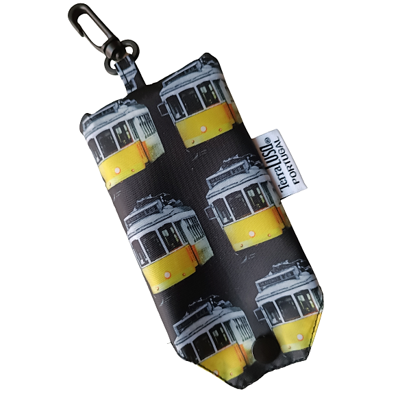 The "Tram" Eco Shopper pouch by Terra Lusa features yellow Lisbon tram designs and a metal clip. A side tag reads ECRAFLYDE PORTUGAL. The bag is photographed against a white background.