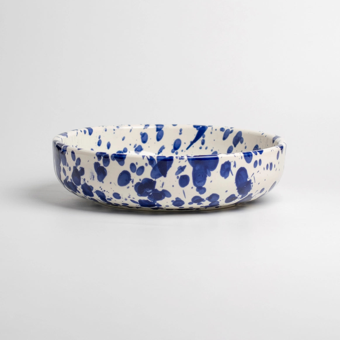 The Tierra Cocida Handmade cheese and vegetable grater plate - PERSIA features a white ceramic base with blue splatter, handcrafted in Spain and ideal for Mediterranean kitchen decor, shown against a plain white background.