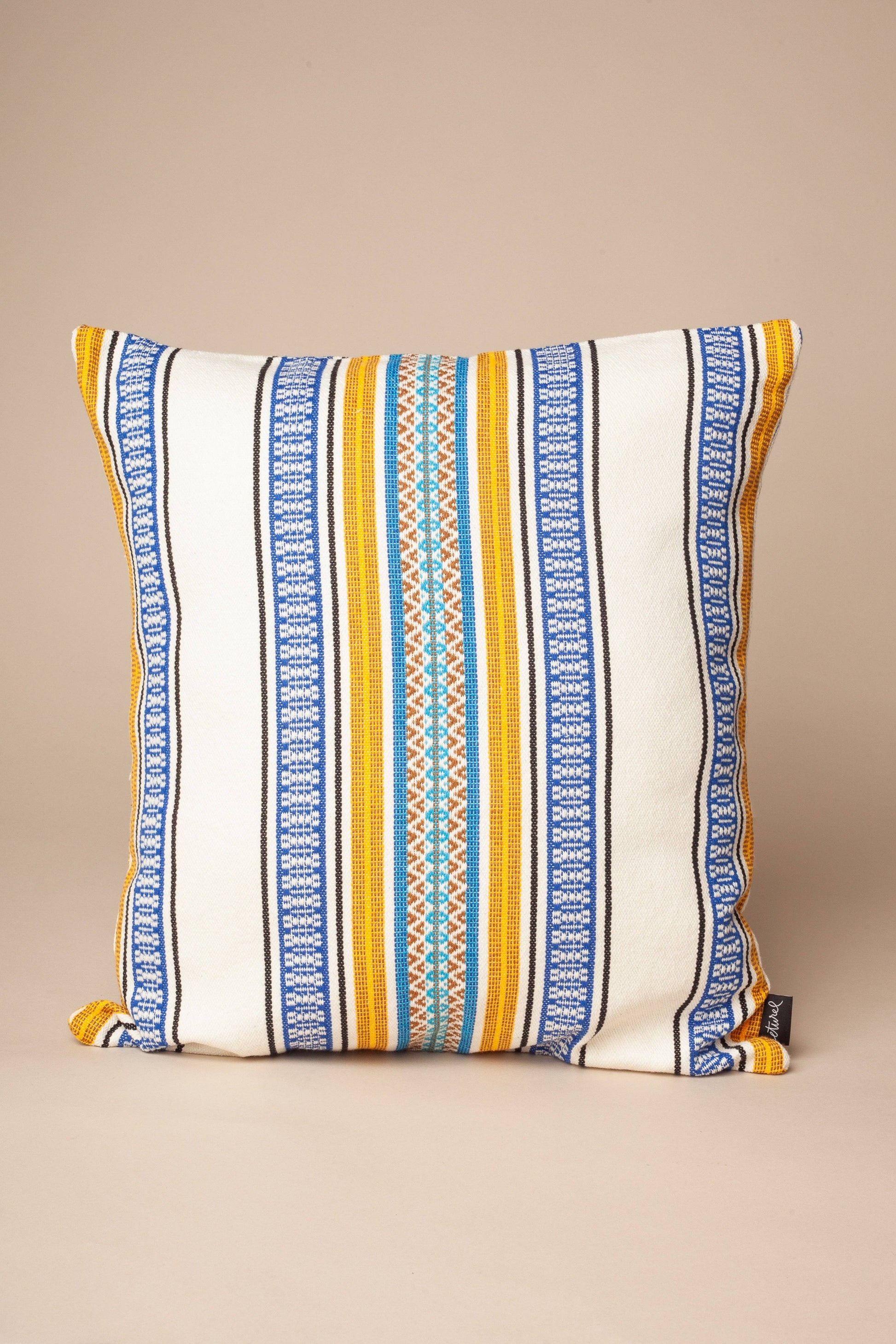 The Eturel Madrid Morellano Blue Woven Cushion Cover (50cmx50cm) features vertical stripes in blue, yellow, orange, and teal on off-white Morellano Fabric, shown against a plain beige background.