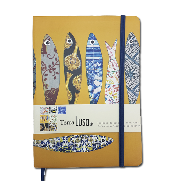 The Terra Lusa Sardines Notebook is yellow with a blue elastic band and five sardine illustrations inspired by Lisbon’s vibrant tile patterns, plus a label featuring Portuguese Cultural Heritage designs.
