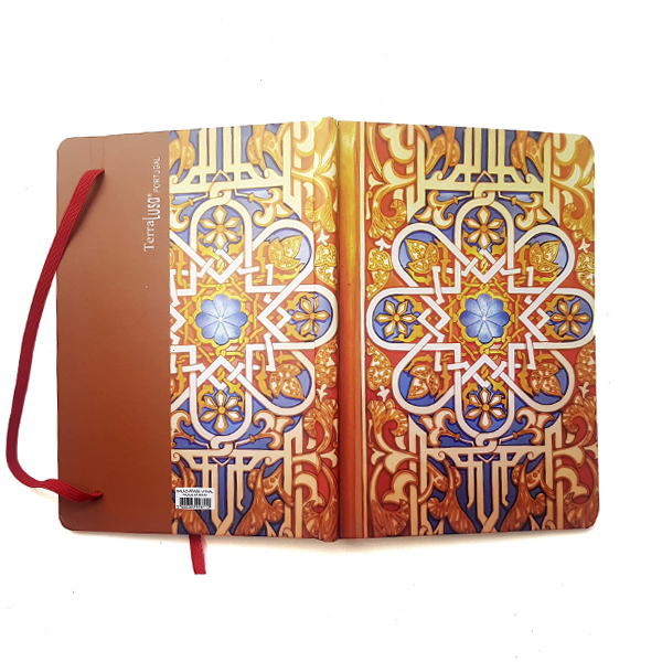The Terra Lusa Stained Glass Notebook features an ornate geometric cover design in blue, gold, and red inspired by Portuguese Heritage, shown open with a red ribbon bookmark and partially unfolded back cover.
