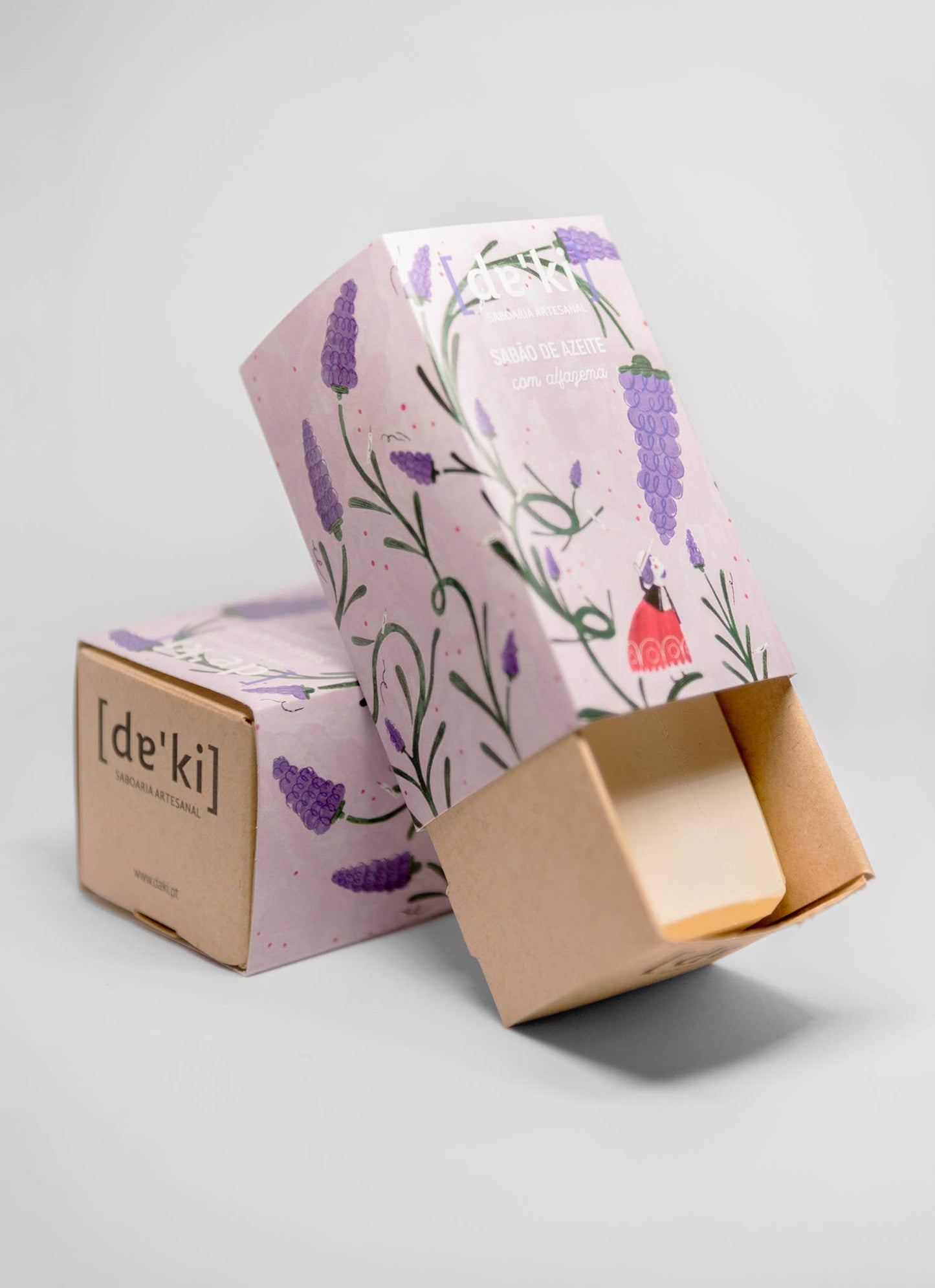 Two handcrafted Olive Oil Soap with Lavender bars by Daki in cardboard boxes, one open to show the soap. Both boxes display lilac and lavender flower designs and the Daki brand name, set against a plain light gray background.