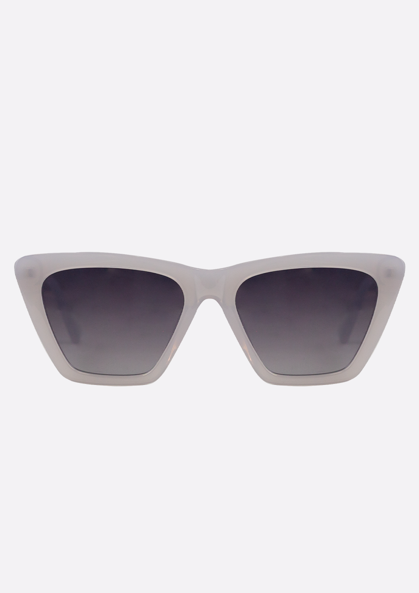 The Perse Crystal Baby Blue sunglasses by Oceanides feature polarized cat-eye lenses and thick, translucent white-blue frames, offering an eco-friendly style. Shown against a plain light background.