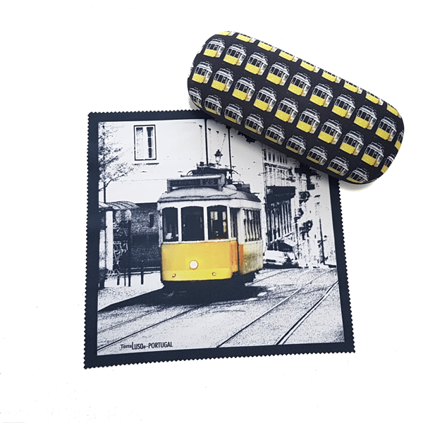 The Terra Lusa "Tram" Glasses Case and cleaning cloth celebrate Portugal's heritage, featuring a repeating tram design on the case and a yellow tram in a black-and-white Lisbon cityscape on the cloth.