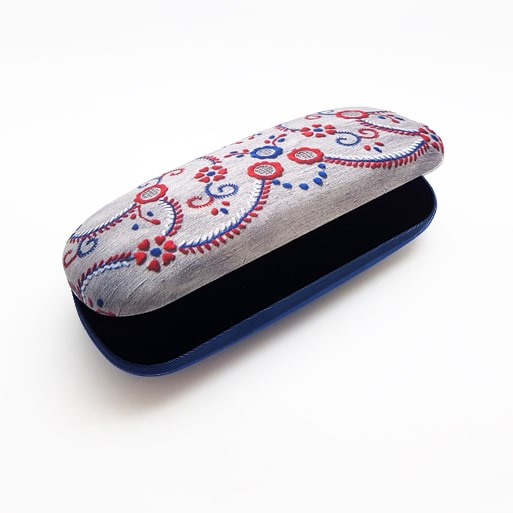 The Terra Lusa "Viana do Castelo" Embroidery Glasses Case, a hard Portuguese case with a gray top and red, blue, and white floral swirl patterns, is shown partially open against a white background.
