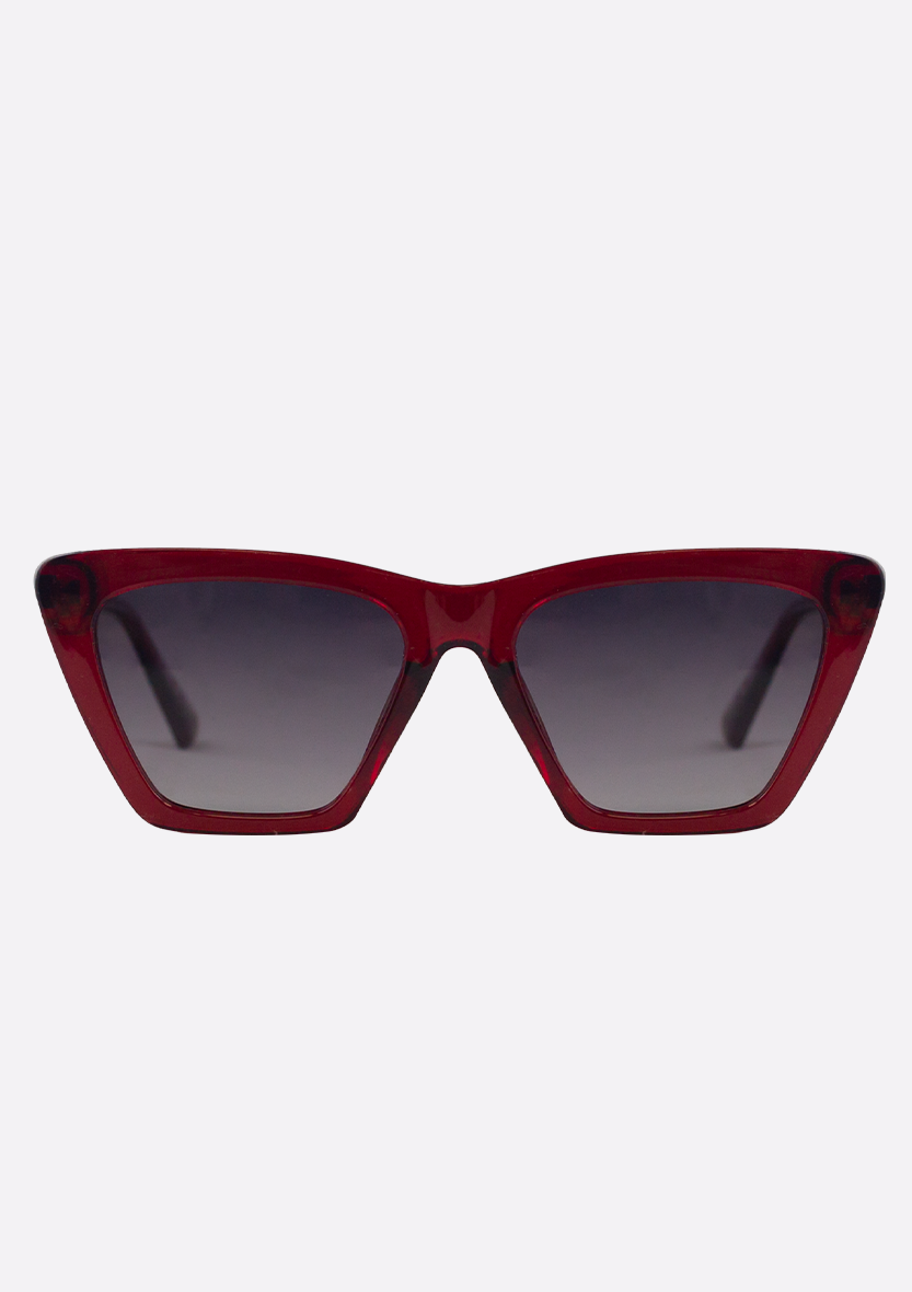 The Perse Crystal Purple Sunglasses by Oceanides feature a bold cat-eye shape and dark gradient lenses, shown front-facing on a white background, blending classic style with eco-friendly design for a chic, sustainable look.