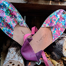The Valentims Ladies Espadrille Sandals by Iberica, featuring colorful floral patterns with pink and purple accents, are displayed on stacked wooden pieces.