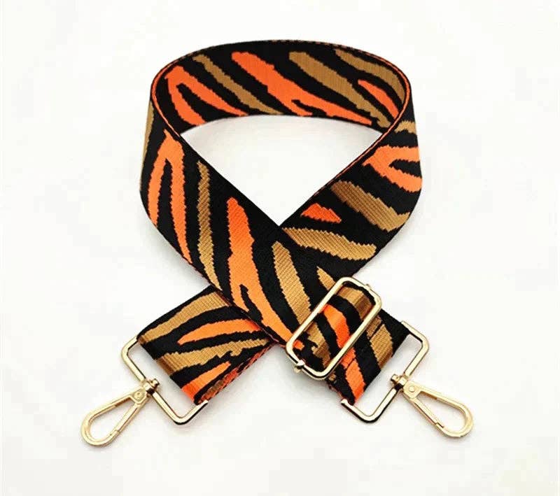 Close-up of zebra webbing and gold-tone clip hardware on 5 cm wide adjustable strap.