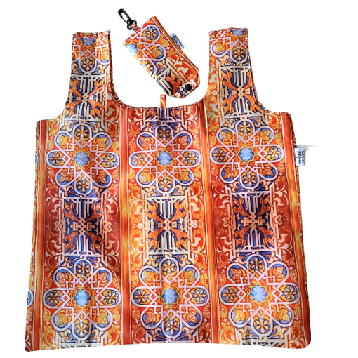 The Terra Lusa Stained Glass Eco Shopper is a reusable bag with matching pouch, featuring vibrant geometric and floral patterns. The pouch includes a black clip for convenience—an eco-friendly shopping essential.