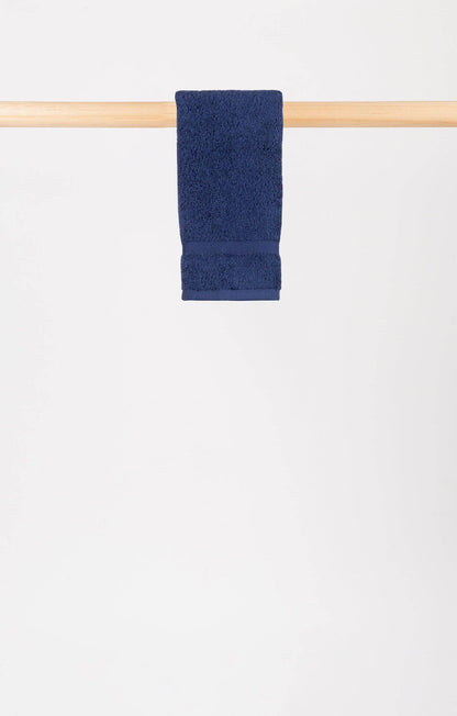 cobalt blue hand towel hanging on a wooden rail