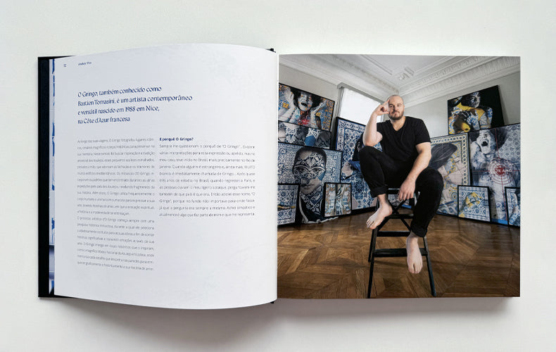 Open book showing a person sitting in a room with art on the walls.