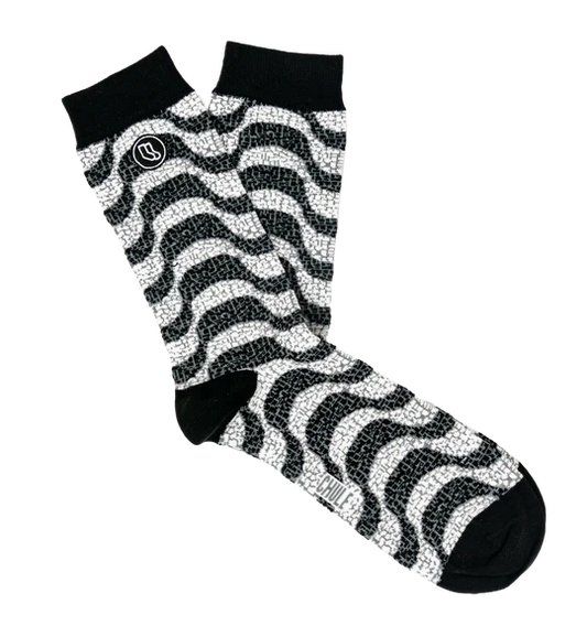 The Souvenir sock box by Iberica - Pretty things from Portugal includes black and white crew socks with a wavy zigzag pattern, solid black toes, heels, cuffs, and a small circular logo near the top of one sock.