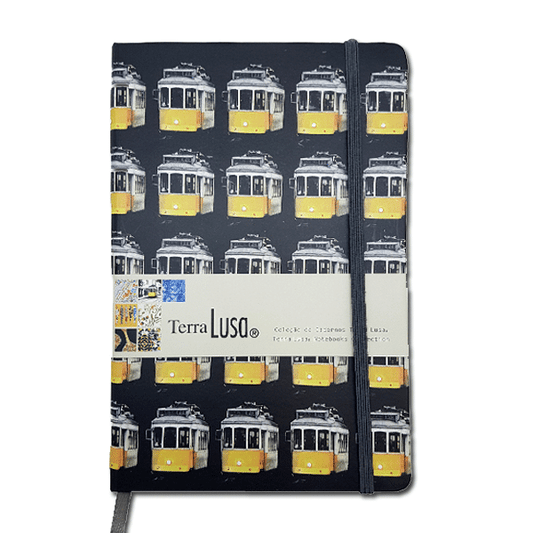 The Tram Notebook by Terra Lusa features a white cover with a repeating yellow tram pattern, celebrating Portuguese heritage. It includes an elastic closure and a branded band labeled Terra Lusa.