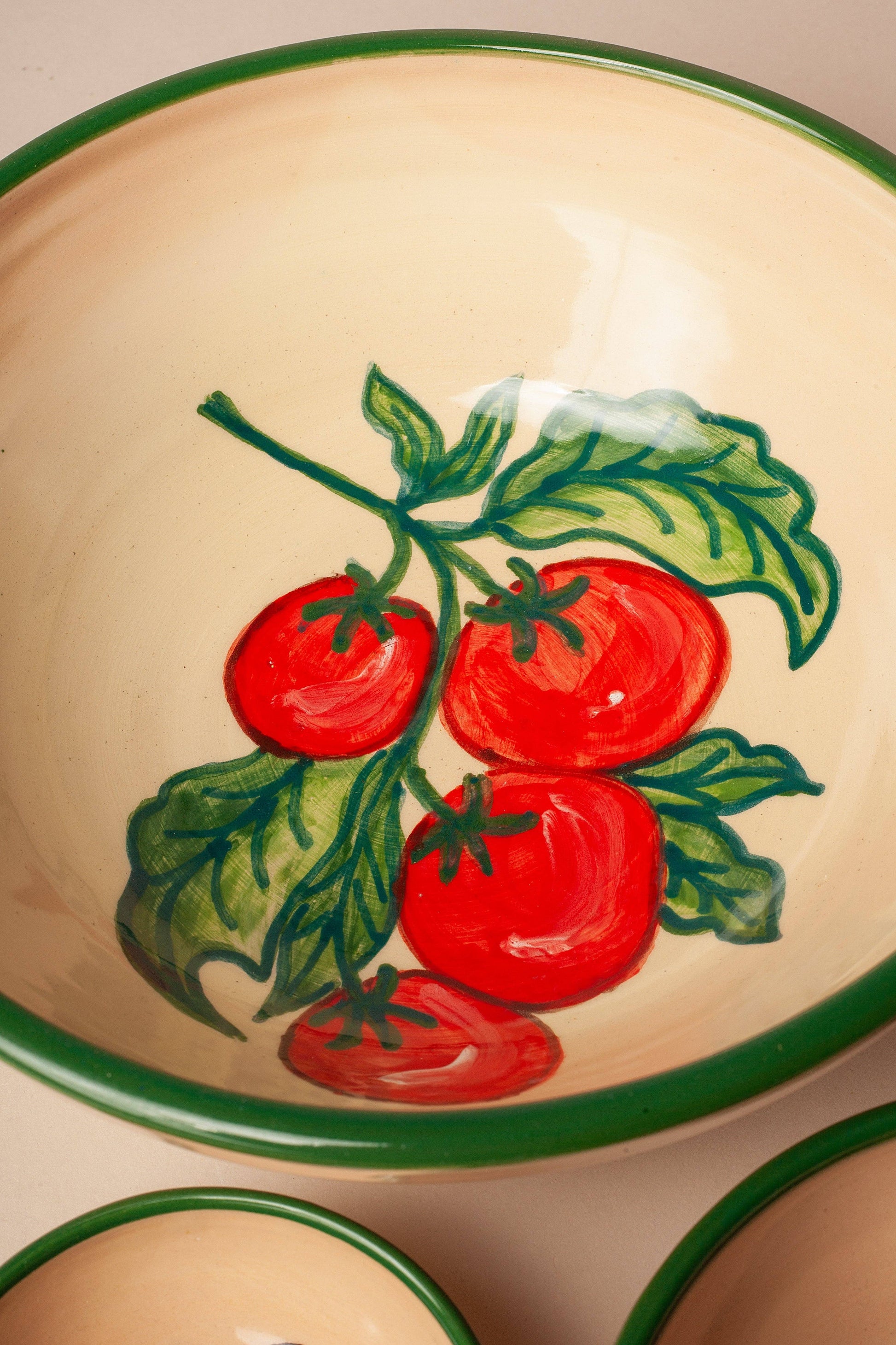 The Eturel Madrid Huerta Stamped Ceramic Bowl features hand-painted red tomatoes and green leaves with a green rim, adding rustic artisanal charm to your table.