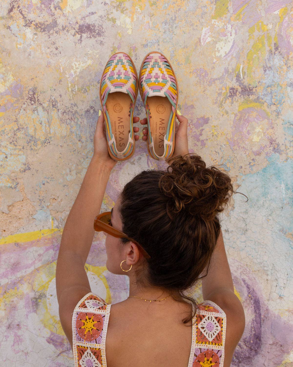 lady holding up pastel leather shoes