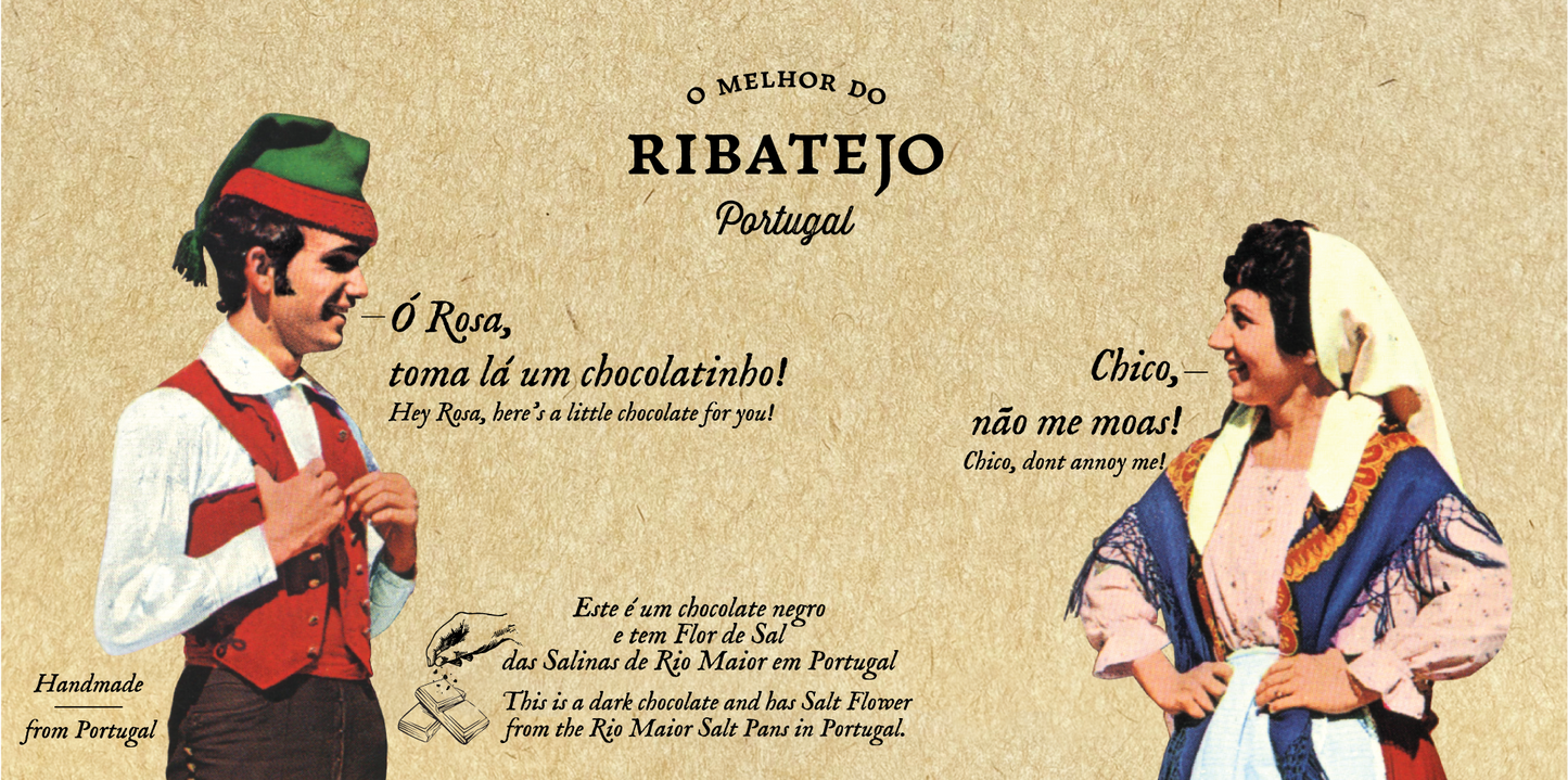 A man and woman in traditional Portuguese dress smile at each other against a beige background featuring English and Portuguese text that highlights O Melhor do Ribatejo’s Dark Chocolate with Flor de Sal, a tribute to Portugal’s culinary mastery.