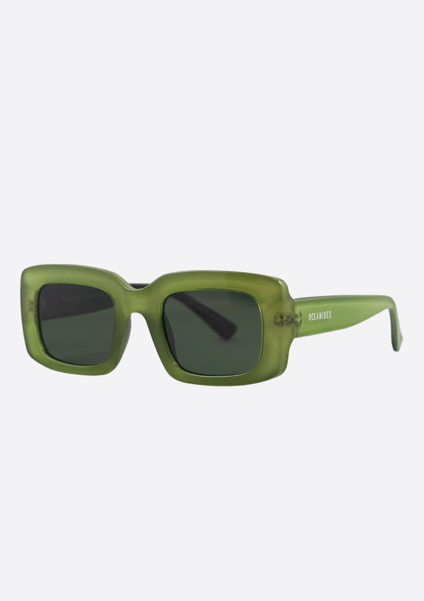 The Oceanides Sunglasses (Polarized) - Ida Crystal Green Black feature rectangular thick frames, dark lenses, and white "OCEANIDES" branding on one arm, offering a stylish minimalist look against a plain light background.