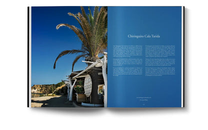 An open coffee table book, The Coolest Ibiza by Loft Publications, displays a beachside bar with palm trees on one page and blue text about “Chiringuito Cala Tarida” on the other, capturing Ibiza’s vibrant spirit.